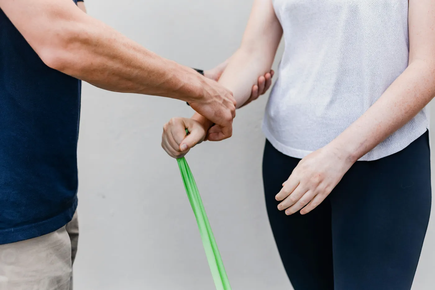 Treinador a orientar um exercício com elástico de resistência